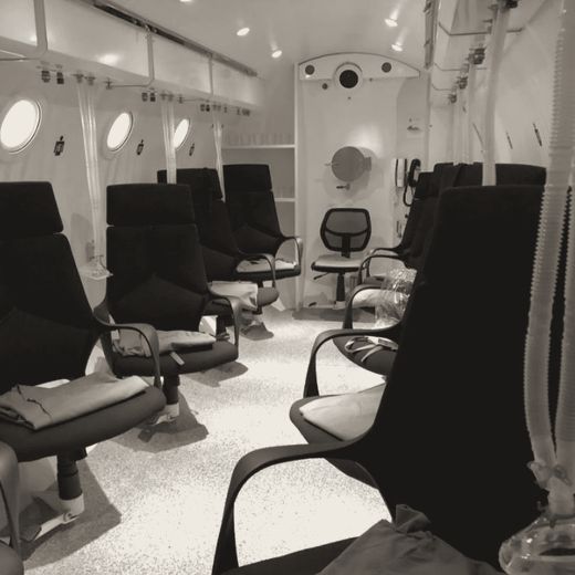 Multiplace chamber interior with seats and demand masks
